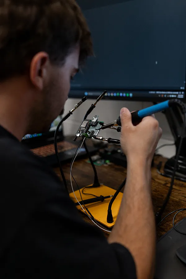 Engineer soldering a circuit board at the electronics bench