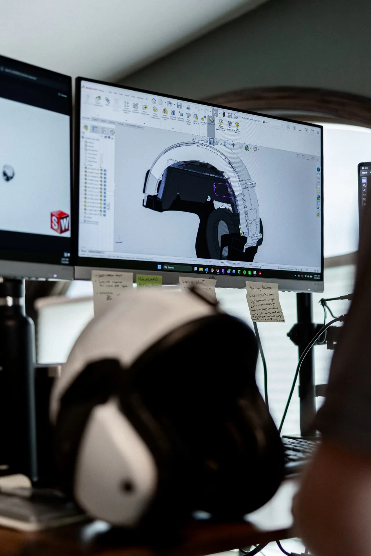 Engineer reviewing a helmet CAD assembly on screen